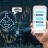 Female hand holding mobile phone showing the chatbot message While being decided place the order over the Stock market chart with cityscape, AI technology concept